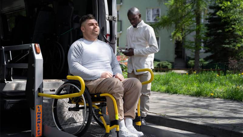 Roadside support provider helping a wheelchair passenger near a van